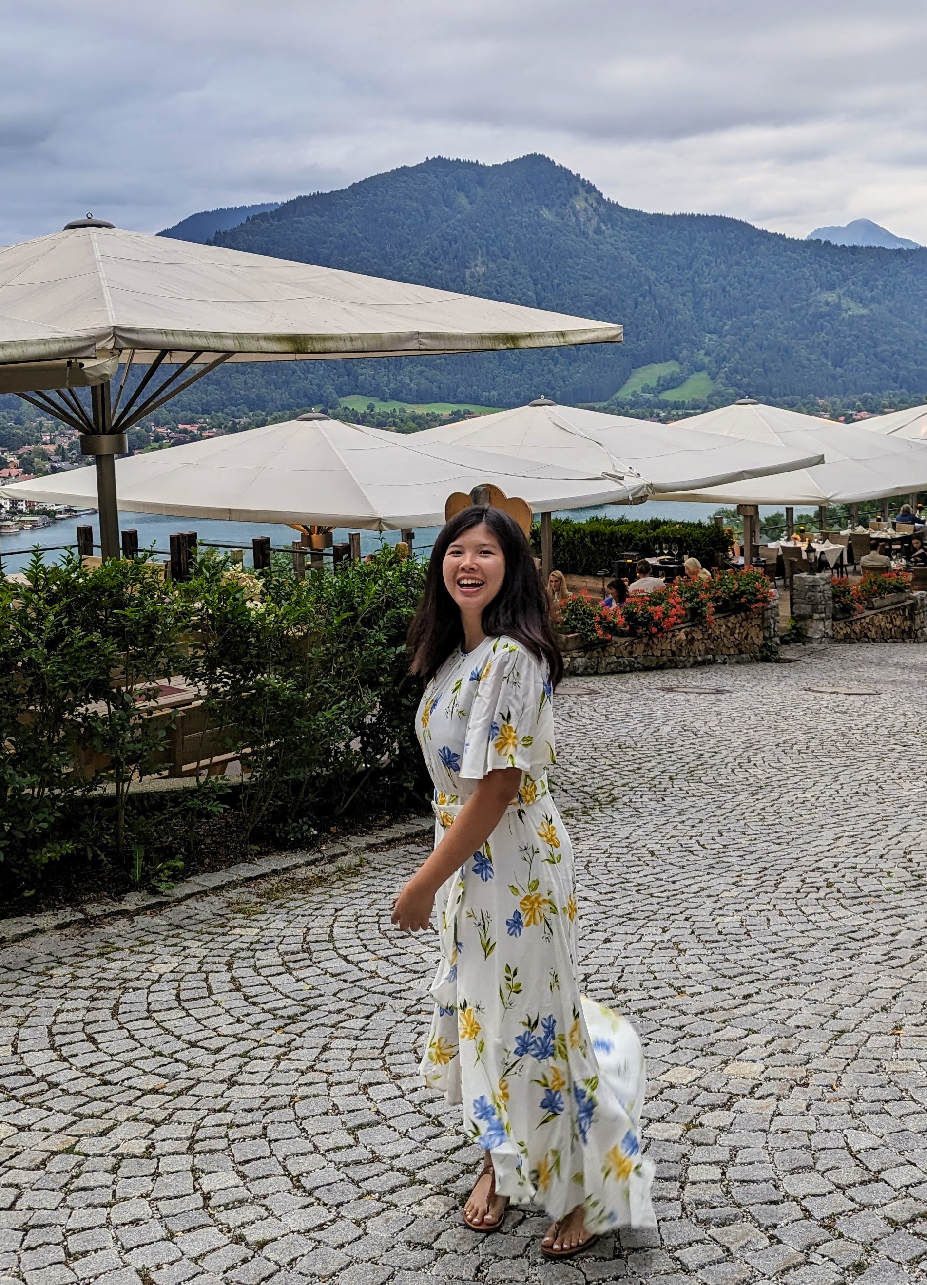 Tze Yi Tan in a white floral dress smiling while twirling